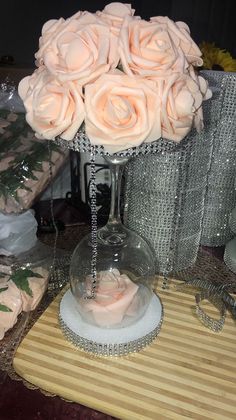 a vase filled with pink roses sitting on top of a table next to other items