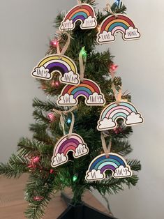 a small christmas tree decorated with wooden rainbows and name tags for the kids to decorate