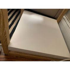 a close up of a white square object on a wooden floor next to a door