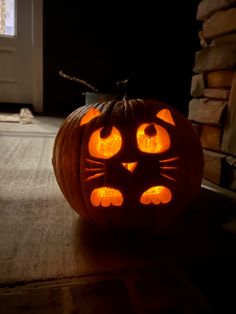 a cat pumpkin carved to look like it has glowing eyes