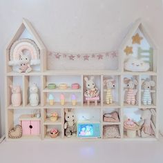 a doll house with lots of toys in it's shelves and decorations on the wall