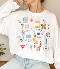 a woman wearing a white shirt with medical icons on it