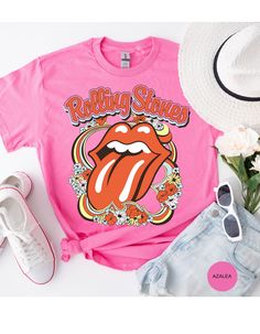 Step back in time and rock out in style with our Vintage Flower Rolling Stone Tee! 🌸🎸 This retro-inspired t-shirt features a classic Rolling Stone logo beautifully intertwined with vibrant flowers, capturing the free-spirited essence of rock 'n' roll and the timeless charm of the 70s. 🌼✨ Crafted from super-soft, high-quality fabric, this tee offers ultimate comfort and a perfect fit, making it an essential addition to your wardrobe. Whether you're heading to a concert, a festival, or just channeling your inner rock star, this tee will have you looking effortlessly cool and totally groovy. 🌟👕 Get ready to roll and bloom with style! 🌿🎶🛒 Spring Festival Hippie T-shirt, Retro Pink Printed T-shirt, Hippie Multicolor T-shirt For Spring, Trendy Festival T-shirt With Graphic Print, Retro Relaxed Fit T-shirt For Music Festival, Retro Graphic Print T-shirt For Spring, Spring Hippie Retro Print T-shirt, Casual T-shirt For Spring Festival, Spring Festival Relaxed Fit T-shirt