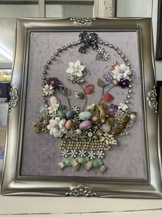 a silver frame with an assortment of jewelry on it