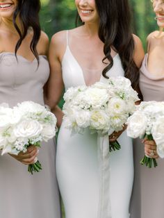 three bridesmaids holding bouquets in their hands