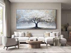 a living room filled with furniture and a large painting on the wall over a white couch