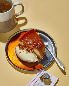 a piece of pie on a plate next to a cup of tea