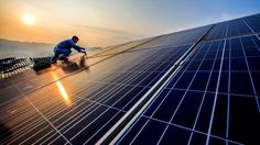 a man working on the roof of a solar panel