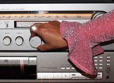 a person's hand on top of an old stereo player with buttons and knobs