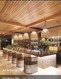 a bar with several stools and lights hanging from the ceiling