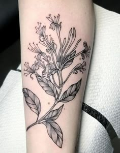 a black and white flower tattoo on the arm