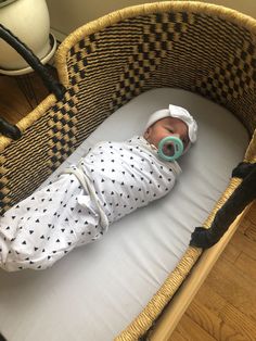 a baby laying in a crib wearing a pacifier