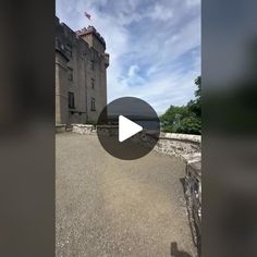 an old building with a flag flying in the background and a video screen showing it