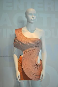 a mannequin is dressed in an orange and white dress with wavy lines on it