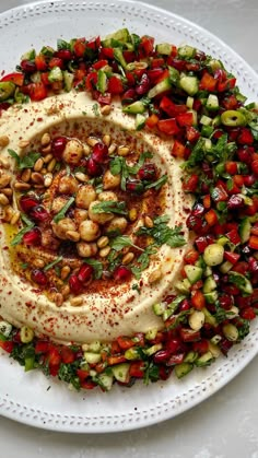 a white plate topped with hummus and veggies