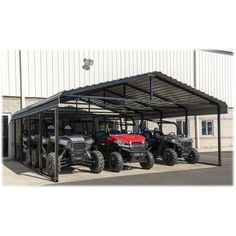 four atvs are parked in front of a building with a roof over them and one is