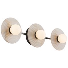 three lights that are on the side of a wall mounted light fixture, one is white and