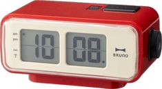 a red alarm clock sitting on top of a table