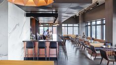 an empty restaurant with tables and chairs in front of large windows that overlook the city