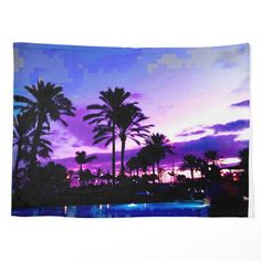 palm trees are silhouetted against a purple and blue sky