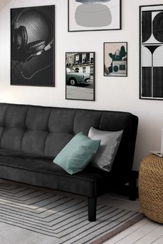 a living room with pictures on the wall and a black couch in front of it