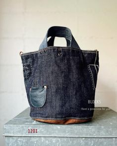 a denim bag with a pocket on the front and side, sitting on top of a table