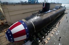 a large black submarine sitting on top of a dock