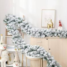 a white christmas garland is hanging on the wall next to a chair and other decorations