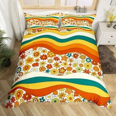 an orange, yellow and green striped comforter set with flowers on the bottom half