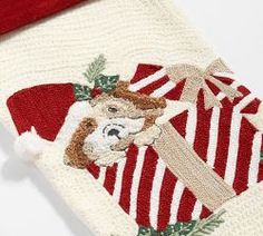 a red and white christmas stocking with a teddy bear on it