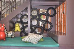 there is a bed with pillows and toys on the floor next to some stairs that are decorated with circles