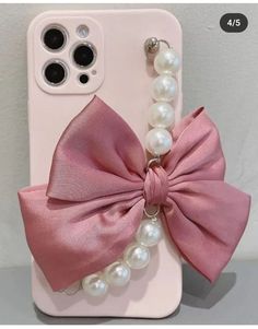 an iphone case with a pink bow and pearls