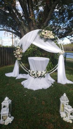 an outdoor wedding setup with white flowers and chairs