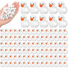 a hand holding a bunch of white and orange rubber ducks with black dots on them