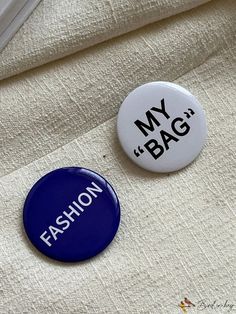 two buttons with the words my bag and fashion printed on them sitting next to each other