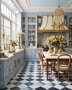 an elegant kitchen with blue cabinets and checkered flooring on the walls, chandelier above the dining room table