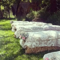 there are many hay bales with flowers on them in the grass near some bushes