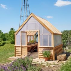 a small wooden building with plants in the yard