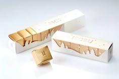 two white boxes with gold foil on them