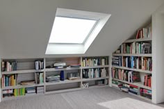 an attic room with bookshelves and skylight