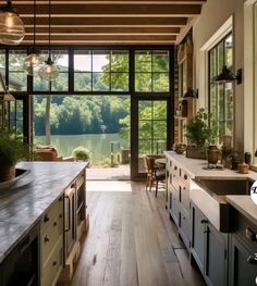 an open kitchen with lots of counter space and large windows overlooking the lake in the distance