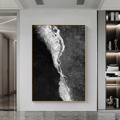 an abstract black and white painting hangs on the wall above a marble floor in a modern living room