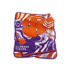 an orange and purple towel with clemson tigers on it's front is laying down