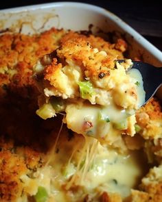 a casserole dish with broccoli and cheese being lifted from the casserole