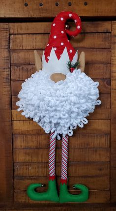 a door hanger with an elf's head and legs made out of toilet paper