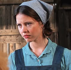 a young woman wearing an apron and hat