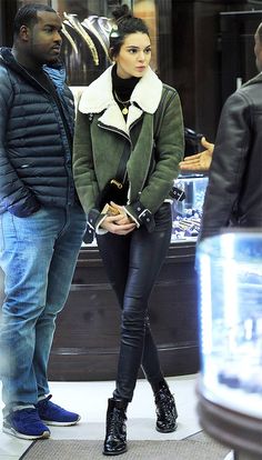 a man and woman standing next to each other in front of a store display window