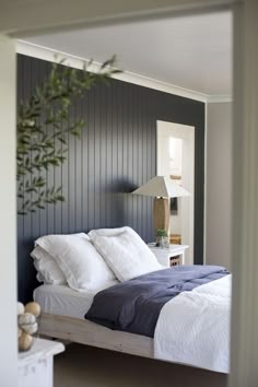 a bed with white and blue sheets in a room