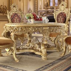 an ornately decorated table and chairs in a room with gold trimmings on the walls