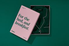 an open box containing a green shirt and the words for the bed, and breakfast